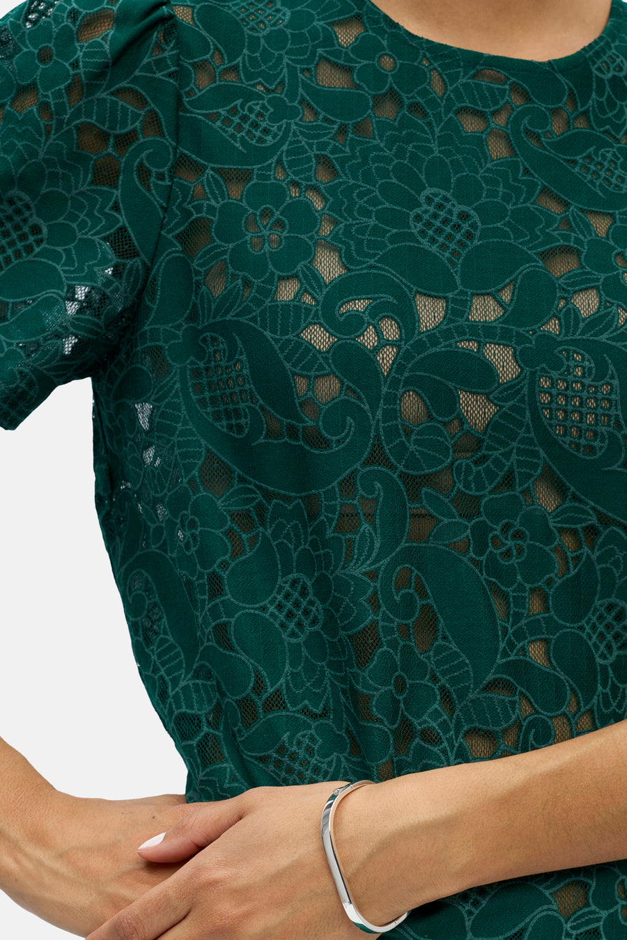 Haut vert à manches courtes de OBJECT, en dentelle à motifs floraux et cachemire, avec un bracelet argenté.