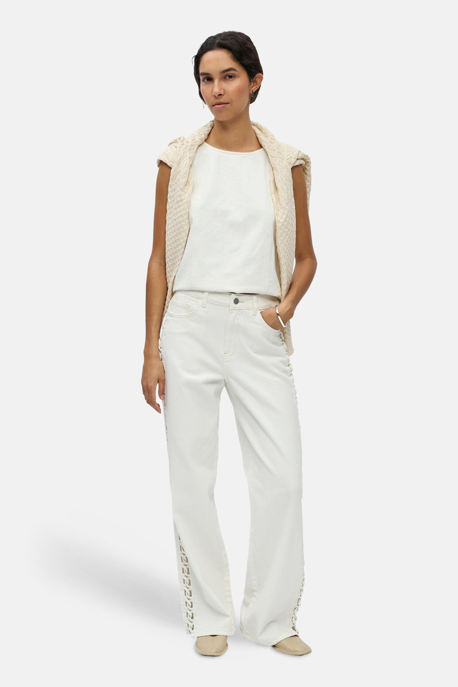 Witte jeans van OBJECT met decoratieve uitsnijdingen langs de zijkanten, gedragen door een model.