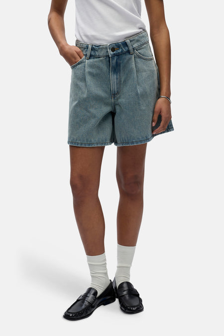 Short en jean bleu clair d'OBJECT, avec des plis et porté avec des chaussettes blanches et des mocassins noirs.