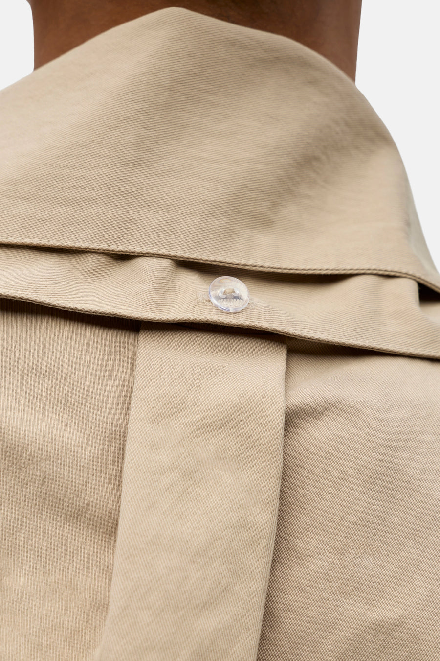 Manteau court beige d'OBJECT, avec une fermeture à boutons visible et une texture structurée.