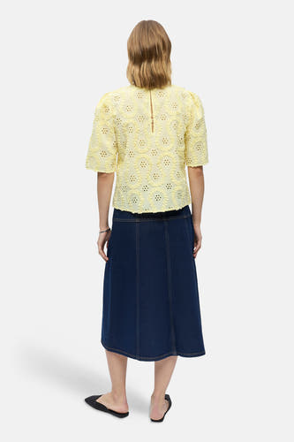 Gele blouse met korte mouwen van OBJECT, met geperforeerd bloemenpatroon en ruches, achterkant zichtbaar op model met spijkerrok.