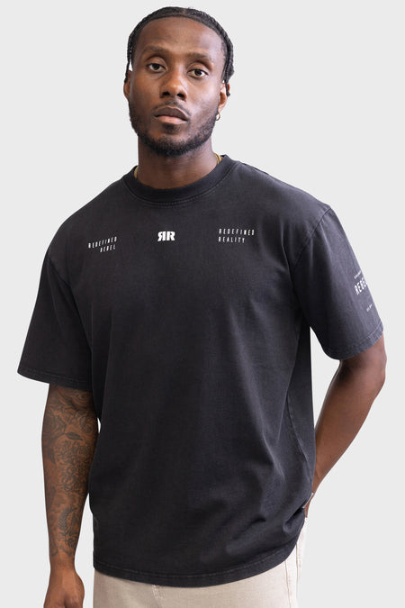Zwart T-shirt met korte mouwen van REDEFINED REBEL, met witte tekst op de borst en een tattoo op de linkerarm.
