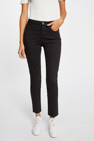 Pantalon noir à 5 poches de Morgan De Toi, coupe ajustée, vue de face avec main dans la poche, associé à un haut blanc et des baskets blanches