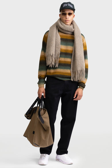 Pull marron avec col rond de REDEFINED REBEL, à rayures horizontales et associé à un foulard, un pantalon et une casquette.