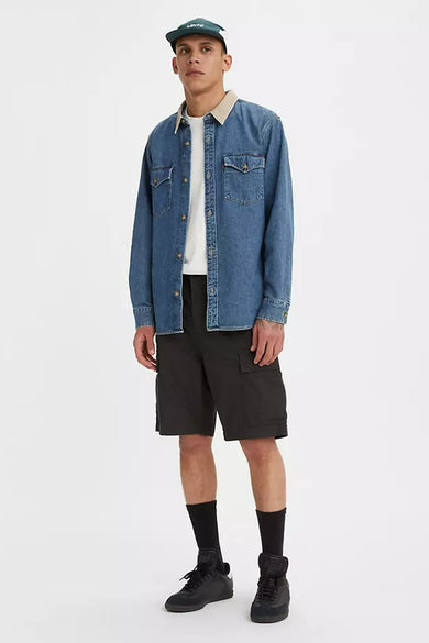 Zwarte short van Levi's, gecombineerd met een denim overhemd, een wit T-shirt en een groene pet.