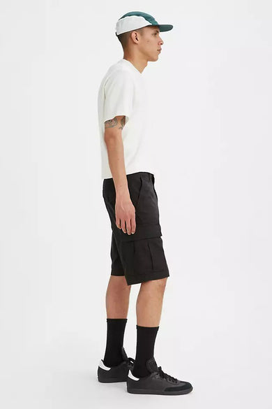 Zwarte short van Levi's®, gezien vanaf de zijkant, gecombineerd met een crèmekleurig T-shirt, zwarte sokken en schoenen, en een pet.
