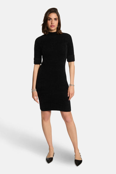 Zwarte jurk met korte mouwen van Morgan de Toi, met een mock neck en zilveren armbanden.
