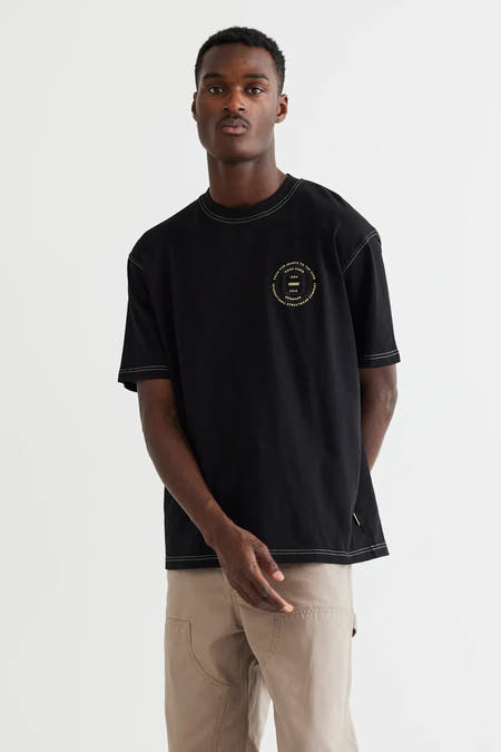 Zwart T-shirt met korte mouwen van WOODBIRD, afgewerkt met crèmekleurige stiksels en een ronde print op de borst.