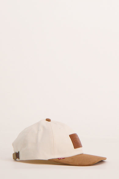 Crèmekleurige pet met bruine details en lederen Levi's logo.