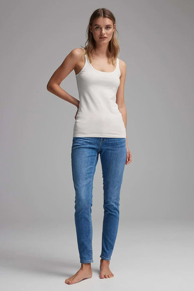 T-shirt blanc OPUS porté avec des jeans bleus sur un fond gris.
