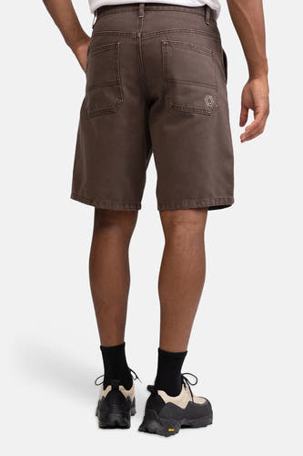 Bruine jeansshort met zakken en hexagon logo van REDEFINED REBEL, achterzijde weergegeven, model draagt wit shirt en zwarte sokken