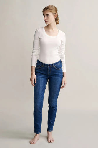 Witte T-shirt met lange mouwen van OPUS, gedragen met blauwe jeans en blote voeten.
