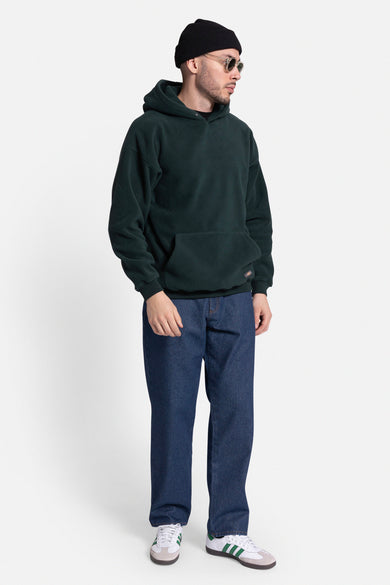 Donkerblauwe straight jeans van REDEFINED REBEL, gecombineerd met een groene hoodie en witte sneakers.