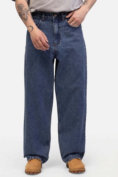 Blauwe wijde jeans van REDEFINED REBEL, met details van used denim en bruine schoenen.
