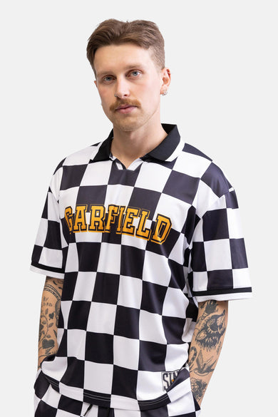 Man met snor, zwart-wit geblokt shirt met 'GARFIELD' in gele letters.