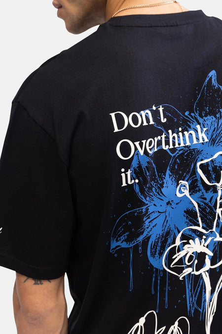 Zwart T-shirt met korte mouwen van REDEFINED REBEL, met bloemenprint en de tekst "Don't Overthink it." op de rug.