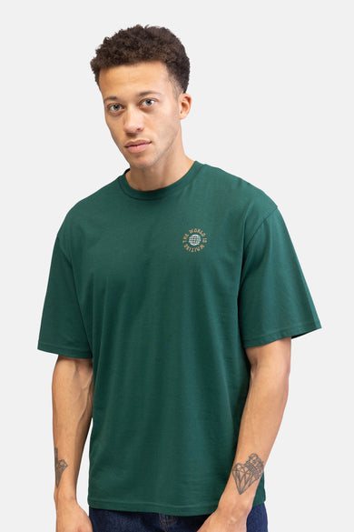 T-shirt vert avec manches courtes de REDEFINED REBEL, avec un petit imprimé sur la poitrine et une tatouage sur le bras.