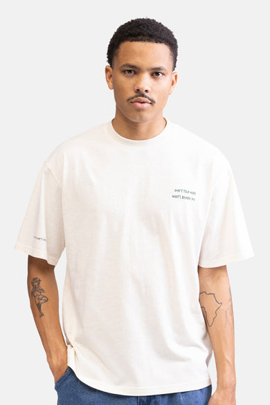 T-shirt écru à manches courtes de REDEFINED REBEL, avec un petit imprimé texte et des tatouages sur les bras.