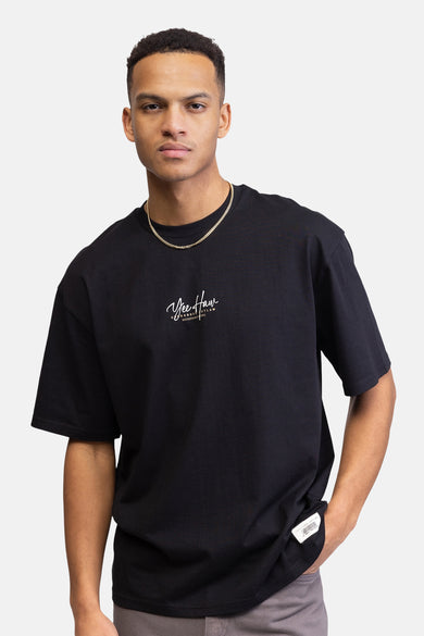 Een man met een zwart T-shirt en gouden ketting.