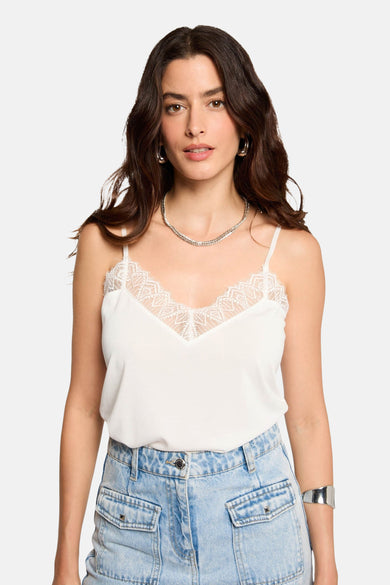 Witte spaghettitop van Morgan De Toi, met kanten details langs de V-hals, gecombineerd met een jeans short en zilveren sieraden.