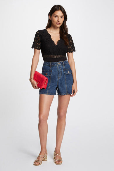 Zwarte body van Morgan De Toi, met kanten details en gedragen met denim shorts en rode tas.

