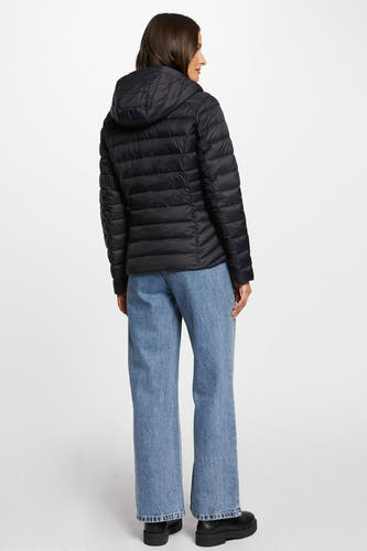 Manteau court noir de Morgan De Toi, avec capuche, associé à un jean bleu et des chaussures noires.