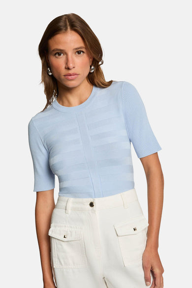 T-shirt bleu avec col rond de Morgan De Toi, à rayures horizontales et porté avec un pantalon blanc.