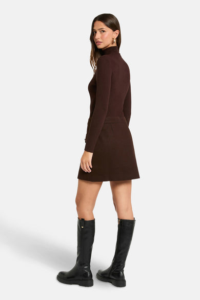 Robe brune à longues manches de Morgan De Toi, portée avec des bottes noires jusqu'aux genoux, vue de derrière.