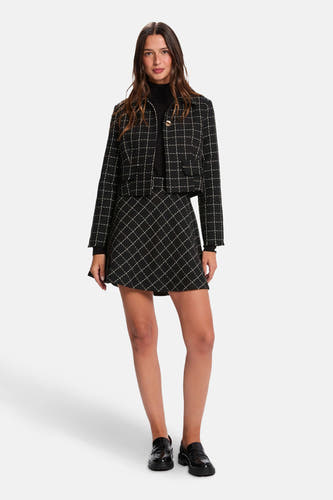 Manteau court noir de Morgan De Toi, avec imprimé à carreaux, associé à une veste et un minirok.