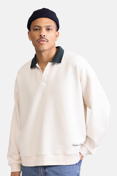 Ecru sweater van REDEFINED REBEL, met donkergroene kraag en subtiele merknaam op de voorkant.