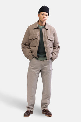 Beige korte jas van REDEFINED REBEL, gedragen met een groene trui en bruine schoenen.