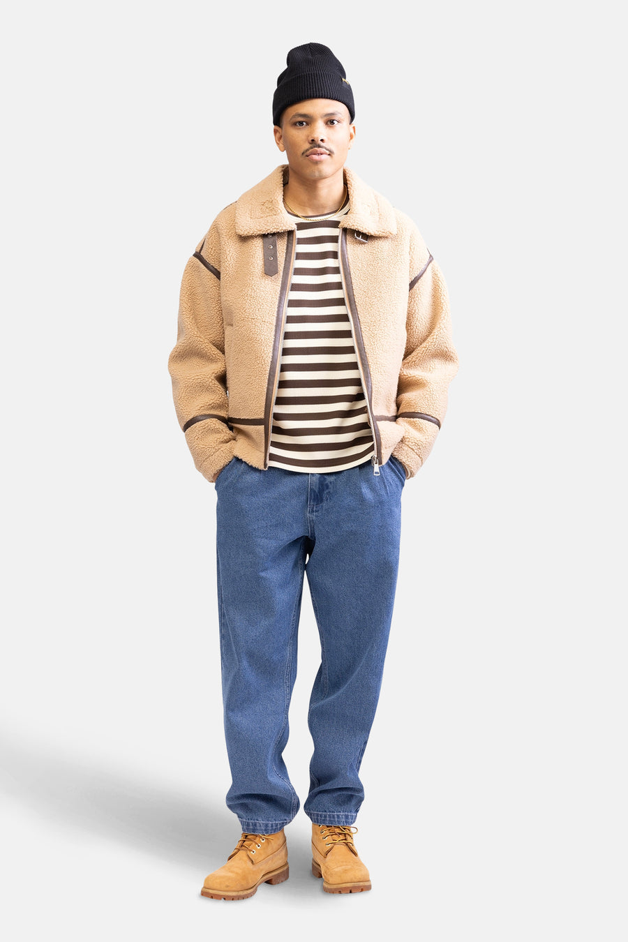 Beige, kort jack van REDEFINED REBEL, met bruine accenten, gedragen met een gestreepte top, jeans en suède laarzen.
