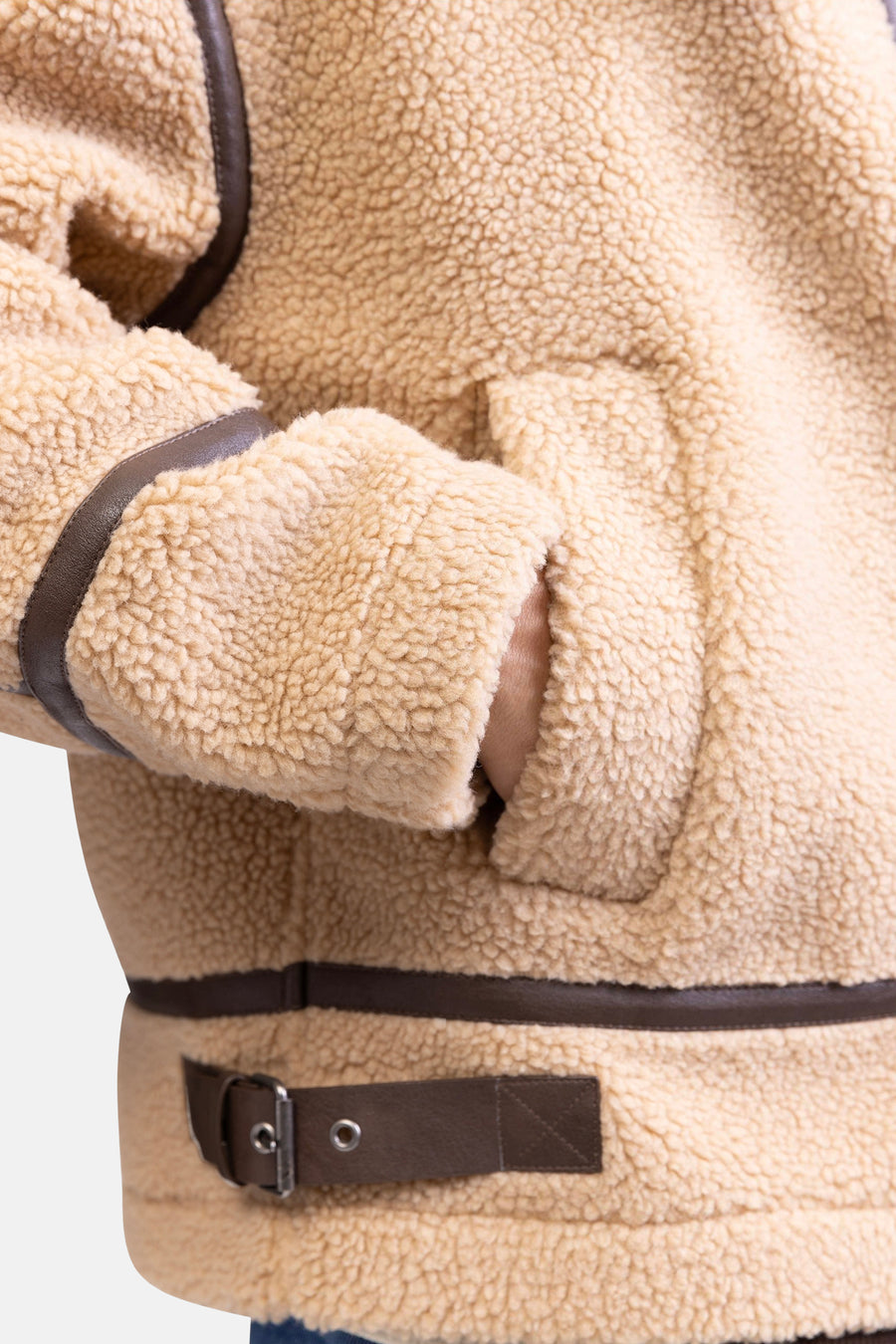 Beige korte jas van REDEFINED REBEL met bruine details en een hand in de zak.
