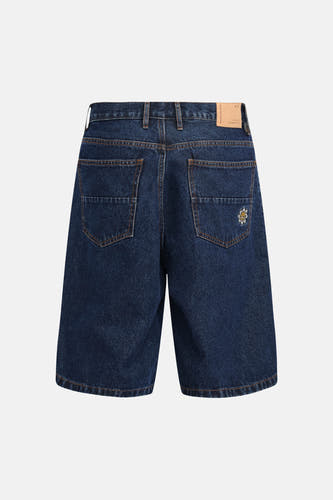 Short en jean bleu marine de REDEFINED REBEL, avec surpiqûres orange, un patch en cuir et une fleur brodée sur la poche arrière droite, vue arrière.