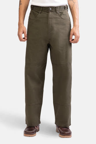Groene broek van REDEFINED REBEL met verstevigde kniestukken, gedragen met bruine schoenen.
