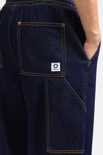 Donkerblauwe denim wijde jeans van REDEFINED REBEL, met stiksels en een wit label op de achterzak.