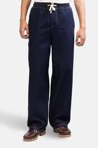 Donkerblauwe denim wide jeans van REDEFINED REBEL met elastische tailleband en bruine leren schoenen.
