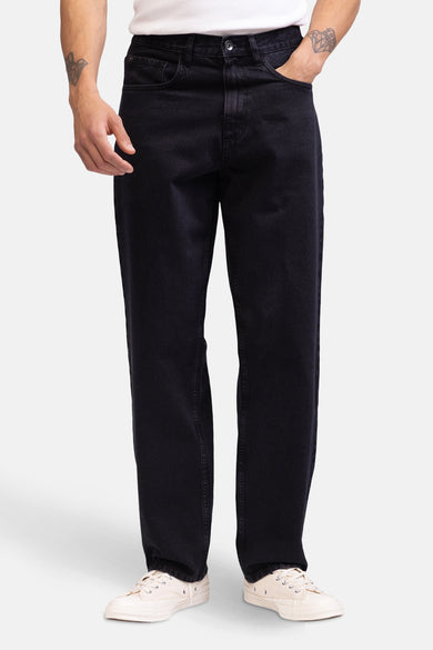 Zwarte wijde jeans van denim van REDEFINED REBEL, met witte schoenen en een deel van een wit T-shirt.