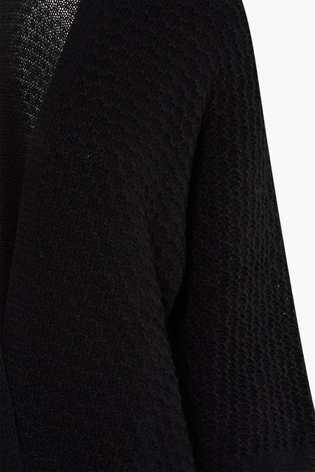 Zwarte cardigan van Terra di Siena, met gebreide textuur en lange mouwen, cropped weergave.
