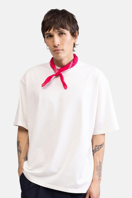 Wit T-shirt met korte mouwen van REDEFINED REBEL, gedragen door een model met rode bandana en tatoeages.