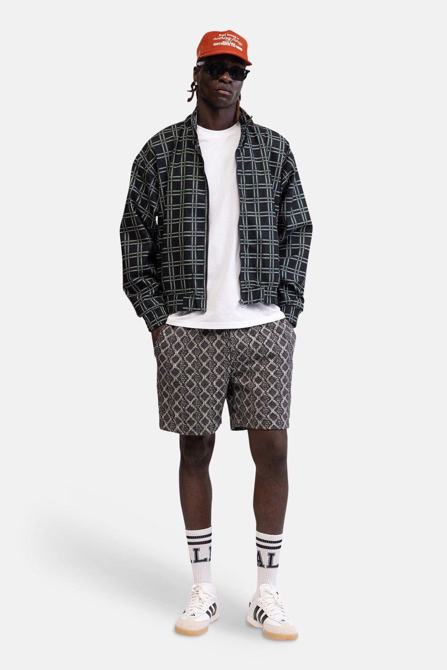 Wit T-shirt van REDEFINED REBEL, casual gestyled onder een geruit jack met rits, met korte broek en sneakers.