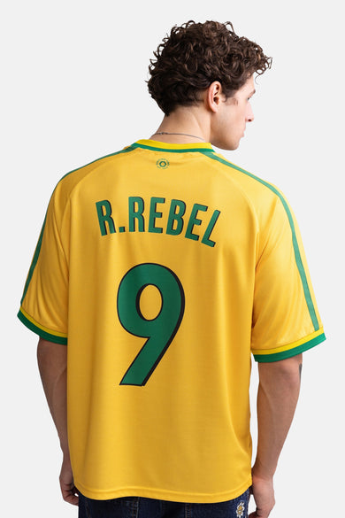 Gele korte mouwen t-shirt met groene accenten van REDEFINED REBEL, rugzijde met R.REBEL en nummer 9, mesh textuur, model in profiel.