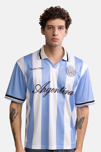 Blauw-wit gestreepte polo van REDEFINED REBEL met 'Argentina' logo en embleem, vooraanzicht model met tatoeages