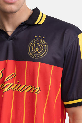 Multicolor polo met donkerblauwe bovenkant en rode gestreepte onderkant van REDEFINED REBEL, goudkleurig logo en schouderaccenten, close-up op model