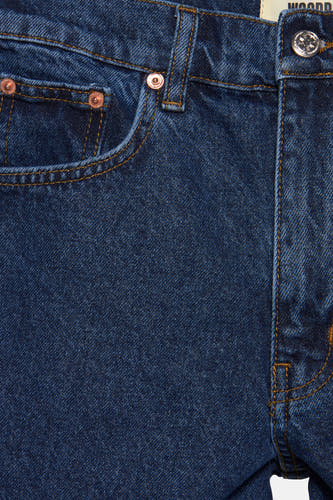 Korte, donkerblauwe jeansshort van WOODBIRD, met koperen knopen en stiksels, close-up.
