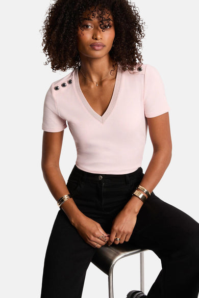 T-shirt rose à manches courtes de Morgan De Toi, porté avec un pantalon noir et des bracelets dorés, vue arrière.