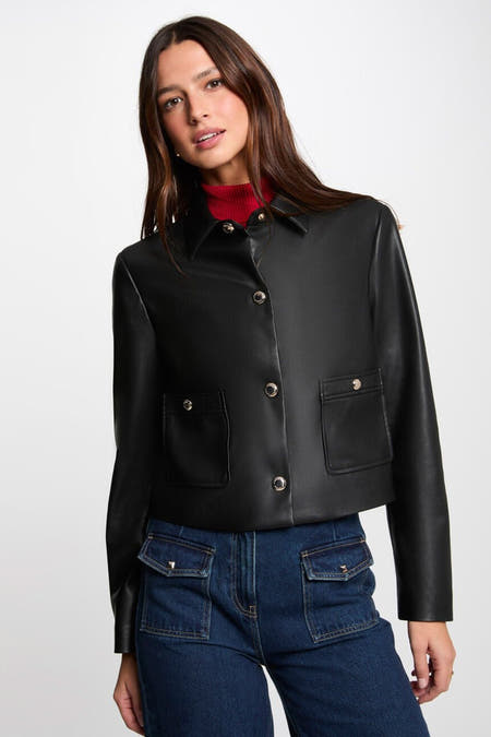 Zwarte korte jas van Morgan De Toi met knoopsluiting, zakken en gecombineerd met een rode coltrui en jeans.