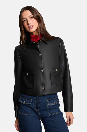 Manteau court noir de Morgan De Toi, avec des boutons argentés et des poches brodées, associé à une veste rouge et des jeans bleu marine à poches.