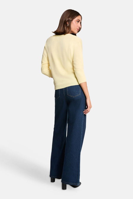 Gele cardigan van Morgan De Toi met driekwartmouwen en geribbelde boorden, gedragen met donkerblauwe wijde jeans, achterkant.