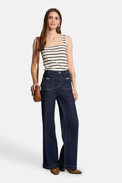 Ecru top zonder mouwen van Morgan De Toi, met een gestreept patroon, gedragen met donkerblauwe jeans en bruine laarzen.
